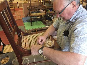student working on laced cane chair
